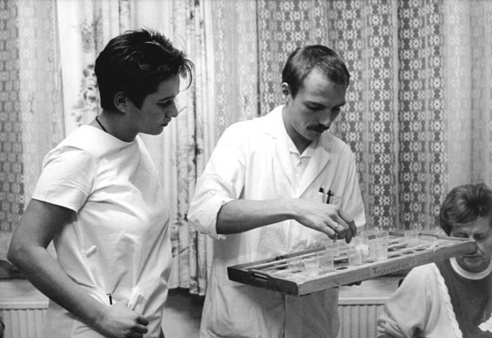 9.11.89 Bez. Leipzig: Gesundheitswesen – Ihre "zweite Schicht" beginnt Medizinstudentin Christiane Sauer. Sie gehört zu den 20 Studenten ihrer Seminargruppe von der Karl-Marx-Universität Leipzig, die sich entschlossen, nach ihren täglichen Lehrveranstaltungen abwechselnd auf drei Stationen im Fachkrankenhaus für Neurologie und Psychiatrie Altscherbitz (Landkreis Leipzig) zu arbeiten, Quelle: BArch, Bild 183-1989-1109-016 / Grubitzsch (geb. Raphael), Waltraud / CC-BY-SA.